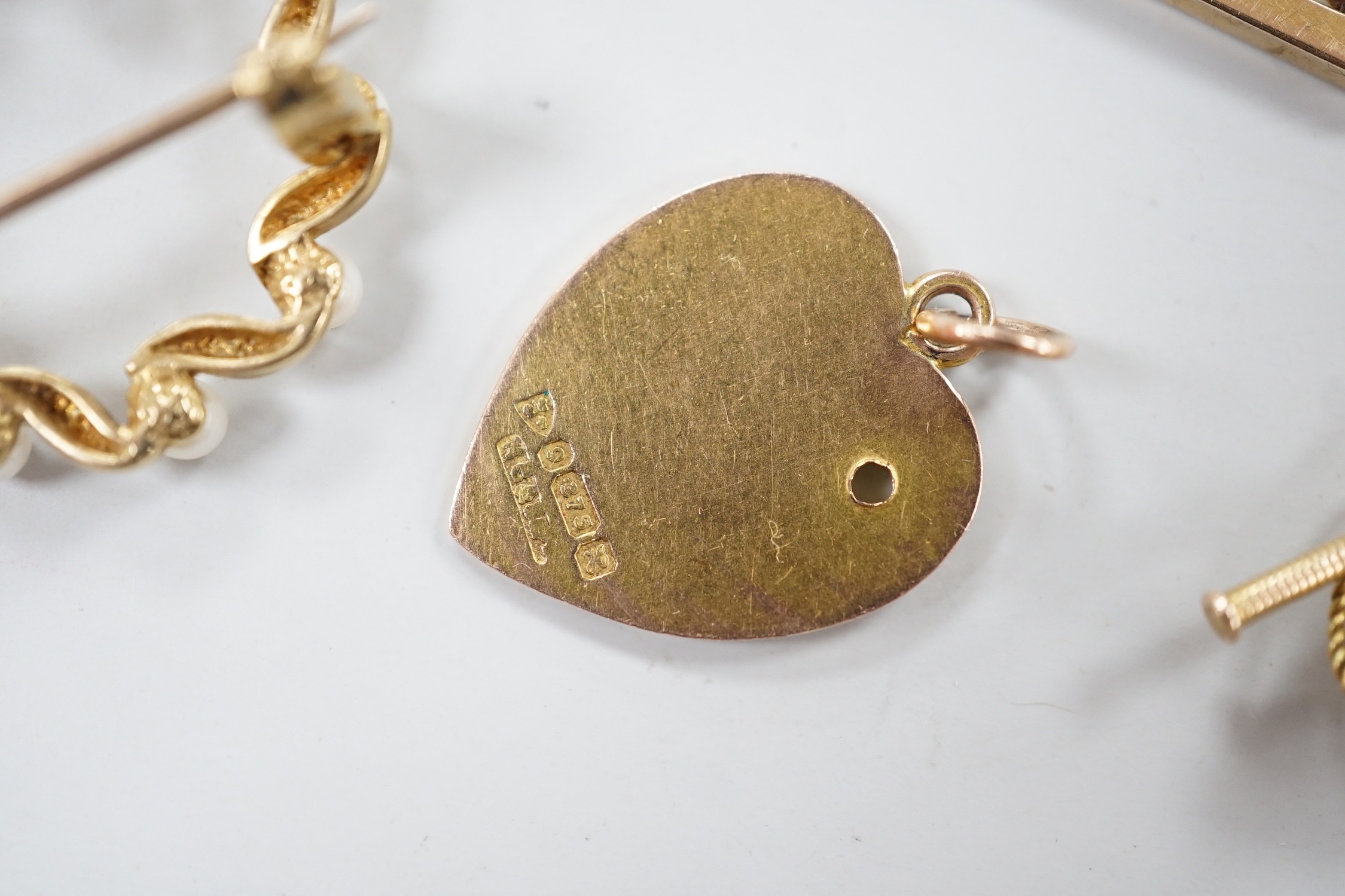 An Edwardian 9ct gold heart pendant (stone missing), 18mm, a yellow metal diablo charm and two brooches including 9ct bar brooch, gross weight 8.1 grams.